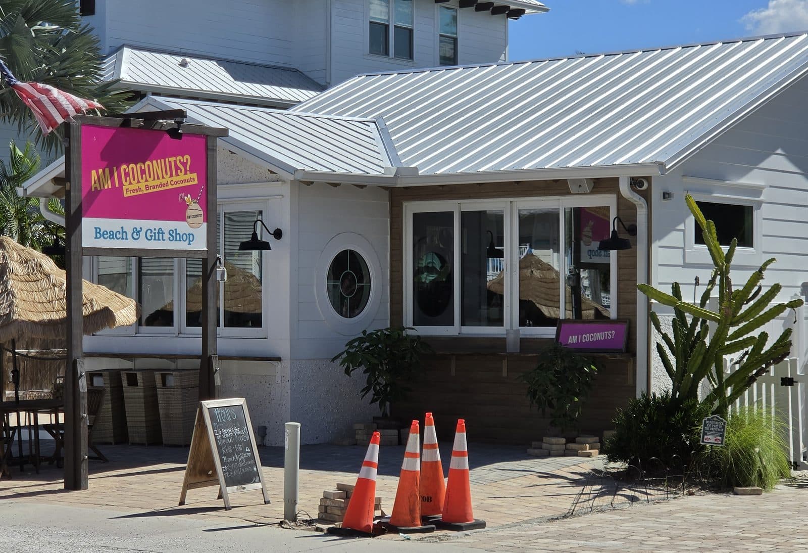 The pink Am I Coconuts? Fresh, Branded Coconuts sign out front of the Beach and Gift Shop