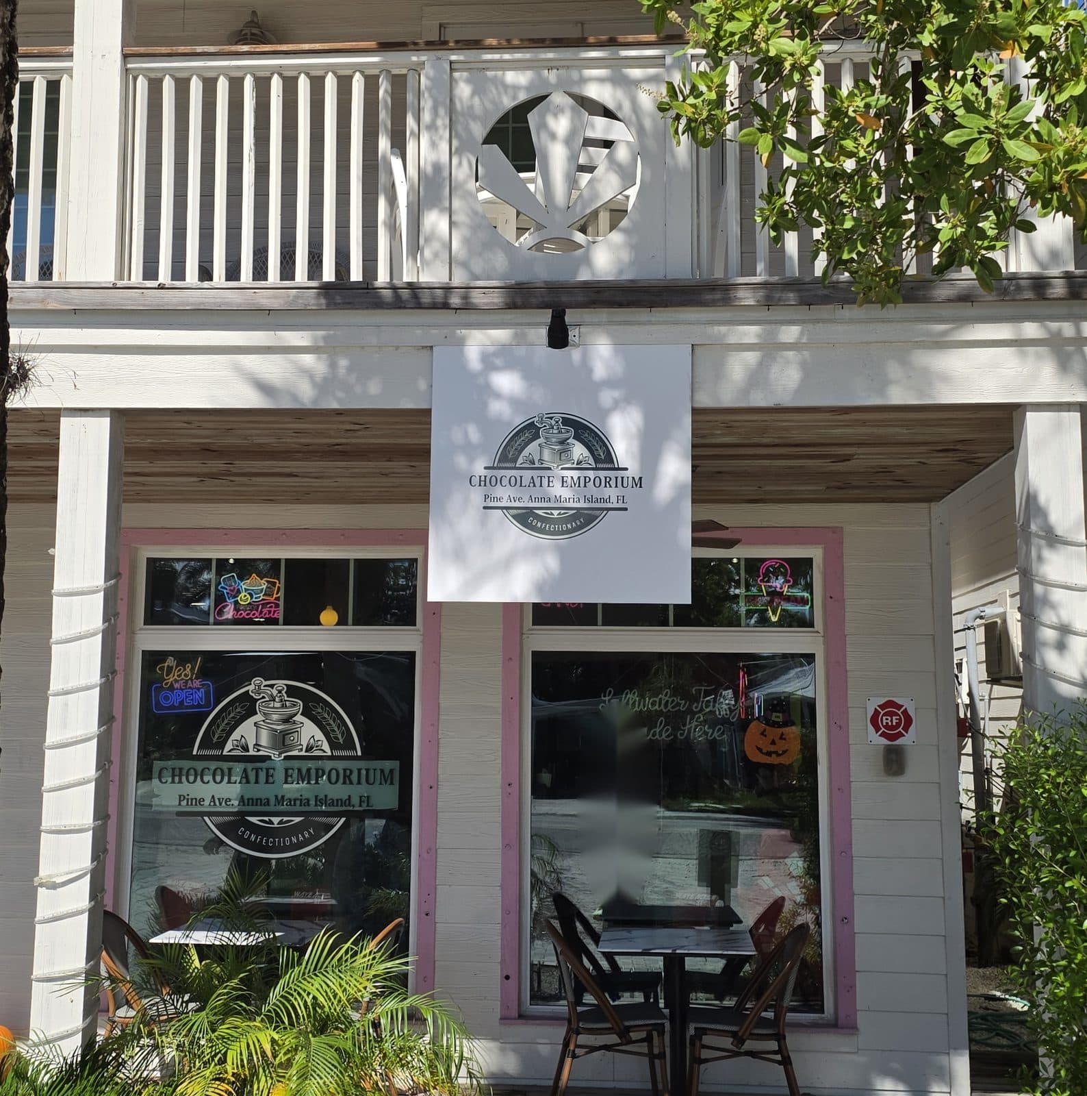 The Chocolate Emporium storefront on Pine Ave, white siding with pink trim