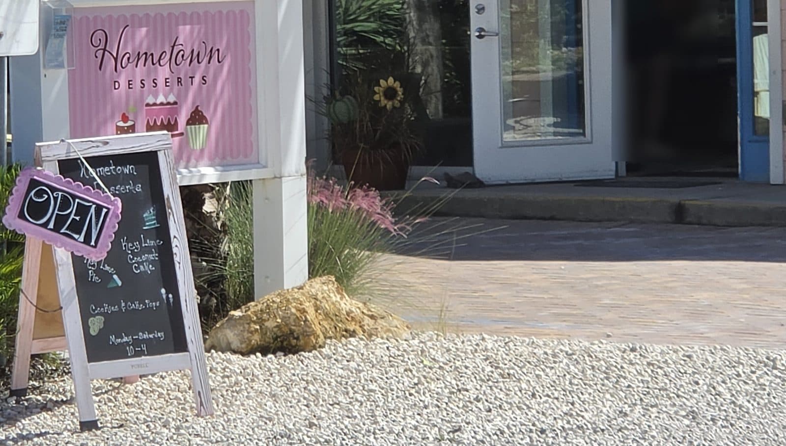 The pink Hometown Desserts sign and chalkboard on Pine Ave, with a pink OPEN heart